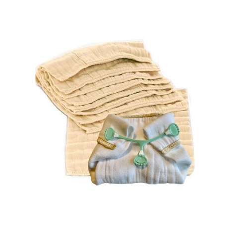 a prefold diaper folded with a snappi fastener and propped up in front of a stack of unbleached prefold newborn diapers